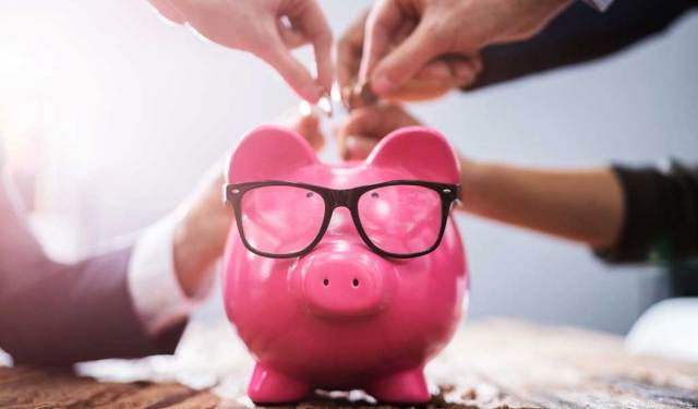 People putting coins into a piggy bank